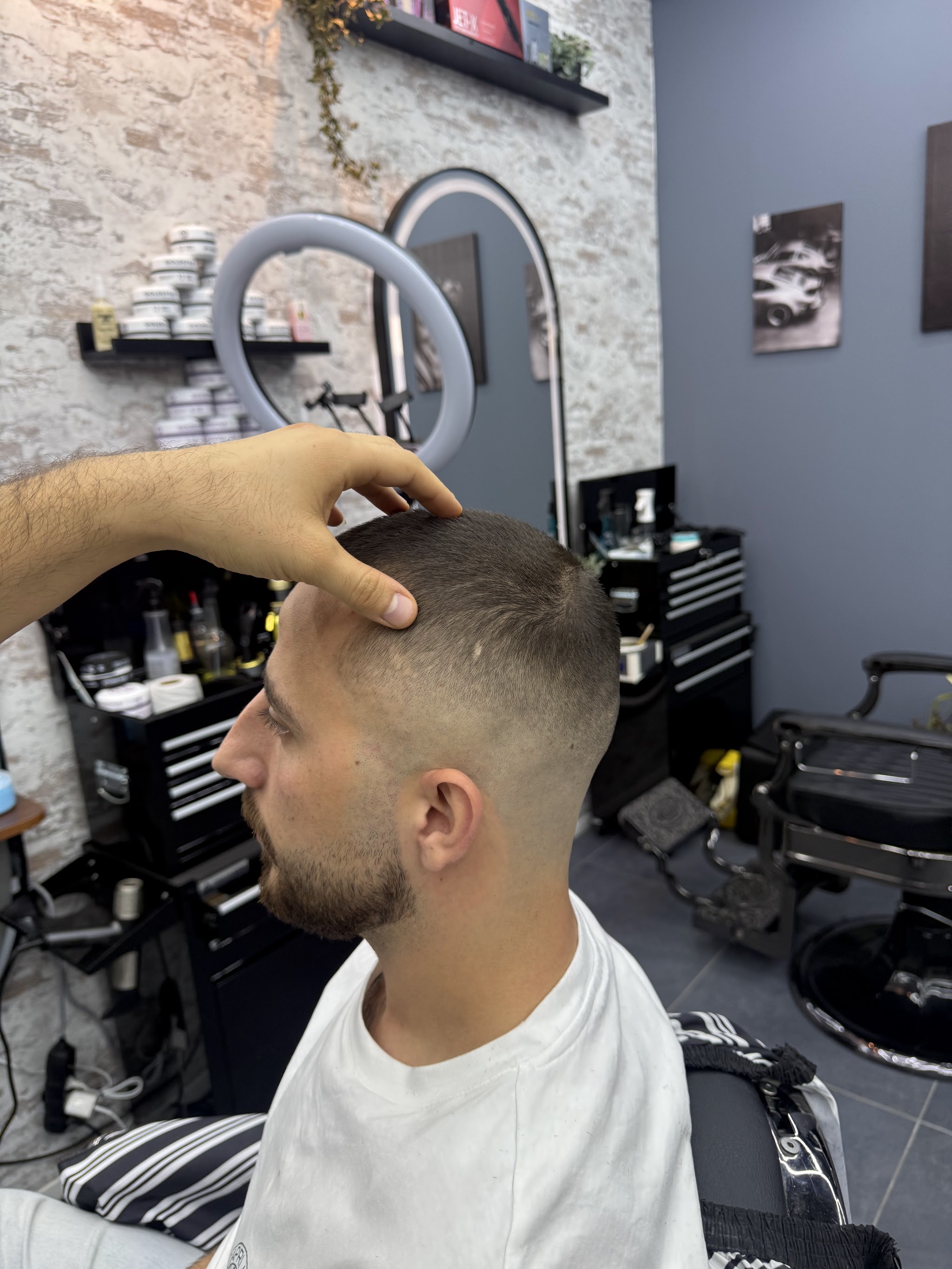 Klant met kort opgeschoren zijkanten in de stoel bij Alpha Hairstyling
